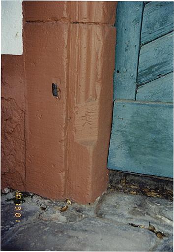 Dépendance, élévation sud. Détail du montant gauche, avec marque de tâcheron, de la porte de la cave haute.