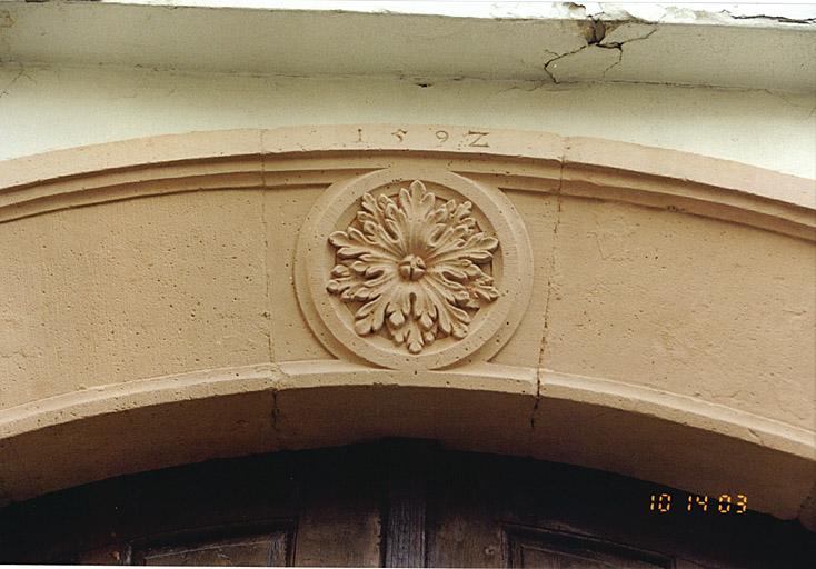 Porte du passage d'entrée. Vue de la rosace et du millésime 1592 sur le cintre.