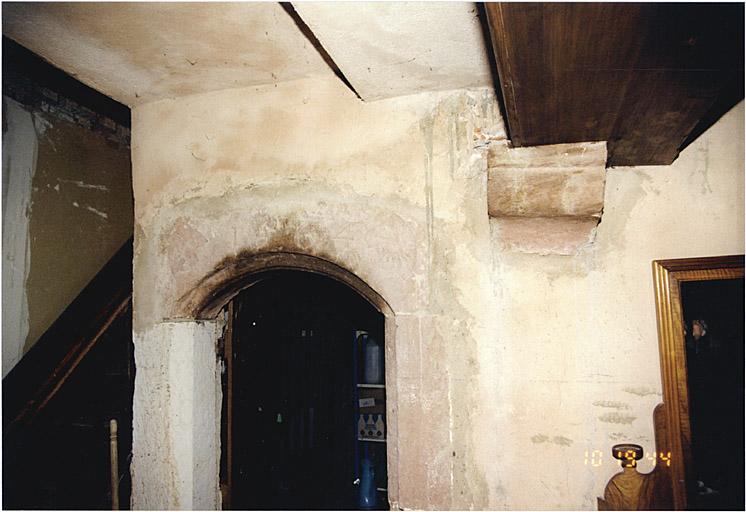 Vue partielle du vestibule avec porte de 1564 et escalier vers l'étage.