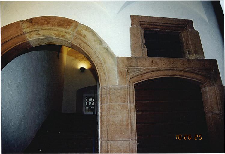 Vestibule voûté avec porte datée de 1623 et arcade vers l'escalier.