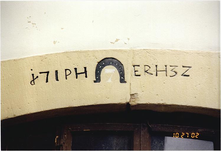 Maison, 2, rue des Cavaliers, détail de la date 1732 et de l'emblème de maréchal ferrant sur une porte.