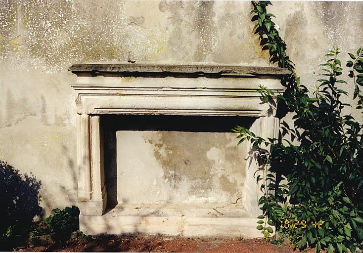 Vue d'une cheminée remployée dans le mur de clôture du jardin.