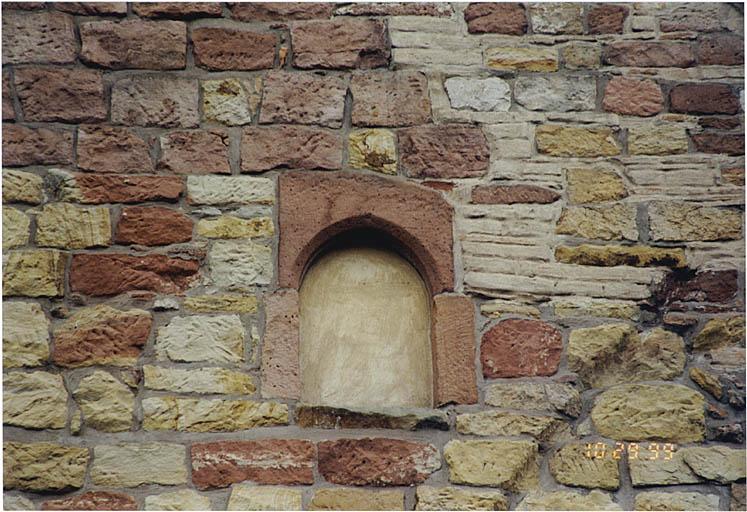 Détail du pignon nord avec baie en arc brisé, murée, et trace du toit d'un bâtiment accolé détruit.