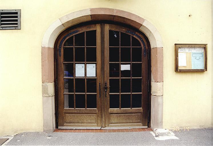 Porte ancienne (restaurée), à l'extrémité sud de l'élévation est.