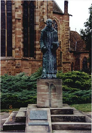 Monument commémoratif (AF), avenue de la Sous-Préfecture. Vue de la statue de moine bénédictin, sculptée par Thierry Delorme, fondue par Blanchet en 1984.