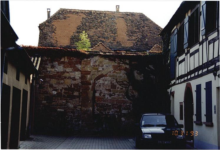 Ancien mur de façade, fermant l'impasse, avec porte murée.