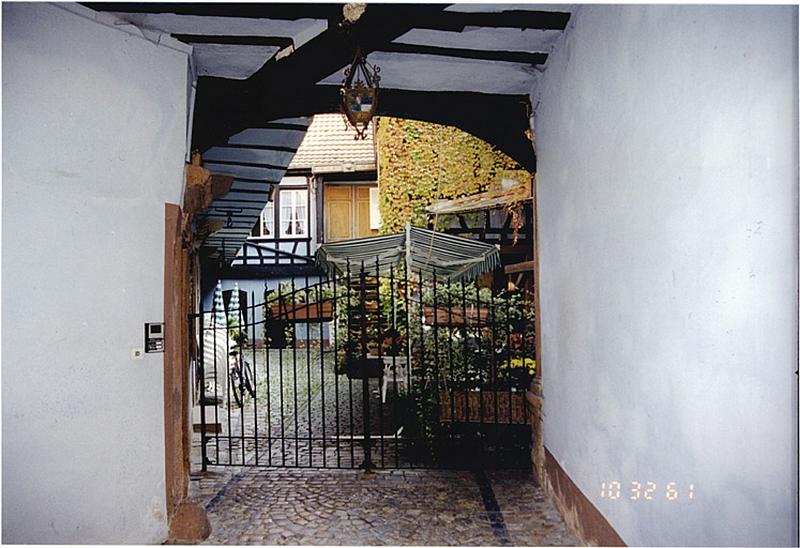 Vue de la cour depuis le passage d'entrée de l'auberge (A). Au fond le bâtiment E.