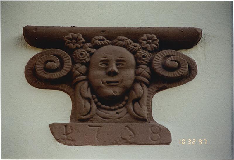 Socle de poêle remployé dans la façade sur rue.
