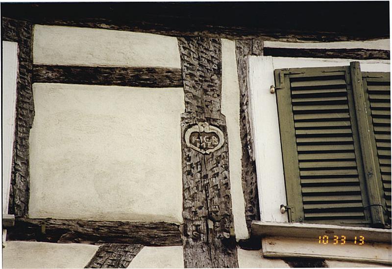 Pignon nord. Détail du poteau central de l'ancienne loggia avec cartouche à initiales.