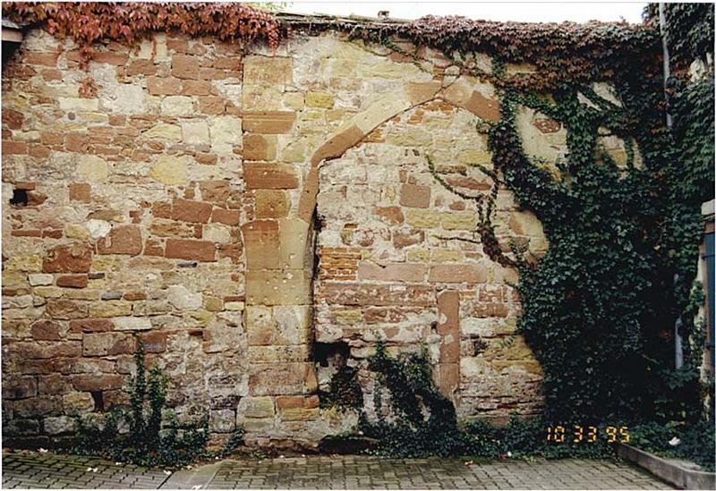 Ancien mur de façade, fermant l'impasse, avec porte murée.