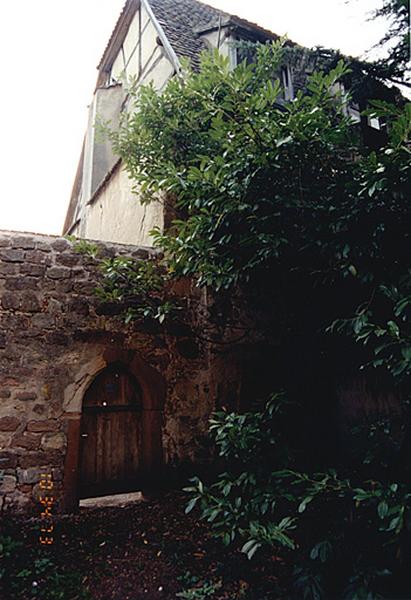 Porte en arc brisé dans le mur de clôture contre le bâtiment conventuel.