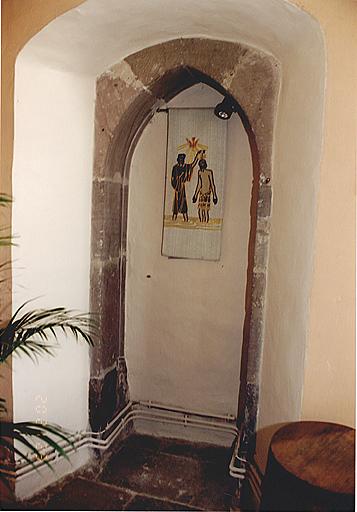 Porte murée vers l'extérieur, située à gauche de l'arc triomphal (vestige de la nef primitive).