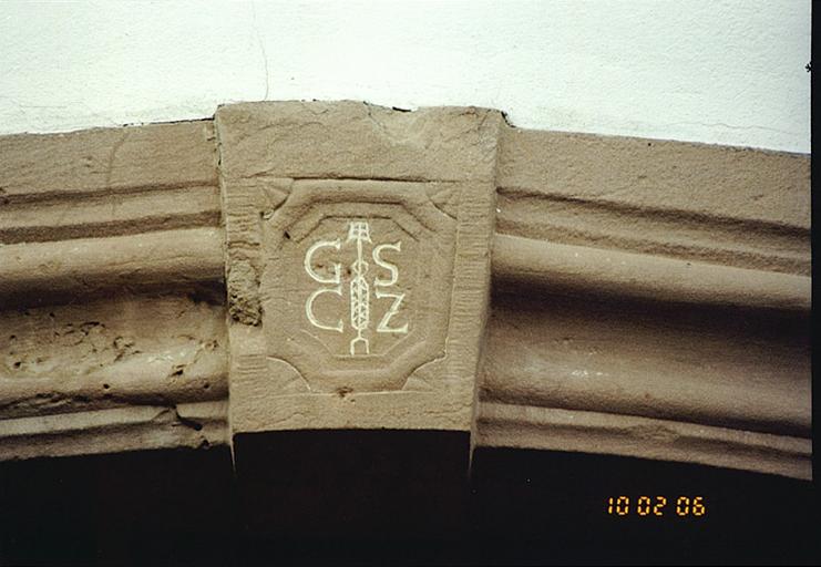 Logis : détail de la porte d'entrée, côté route, avec emblème de brasseur.