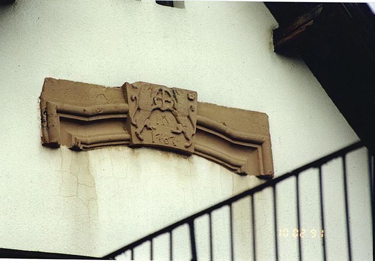 Vue d'un emblème de meunier, sur un linteau de porte, route de Wissembourg (en G sur la carte du patrimoine), déplacé dans le pignon moderne d'une dépendance ancienne.