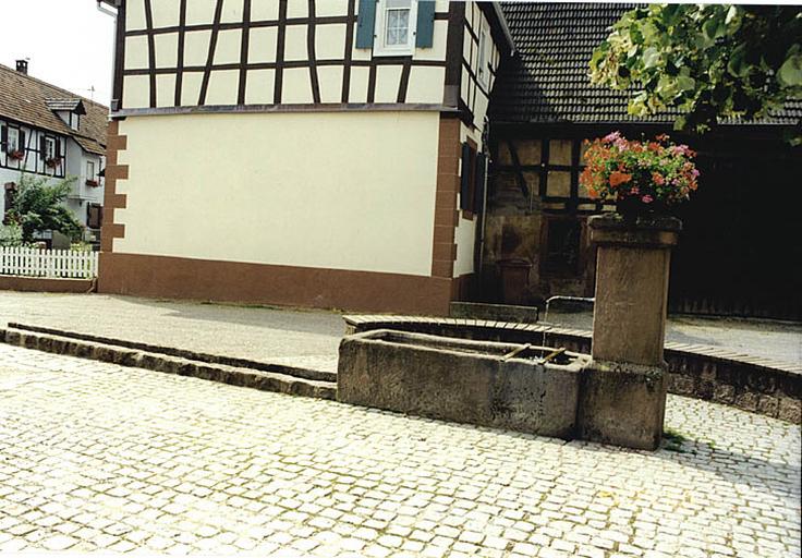 Vue d'ensemble de la fontaine-abreuvoir (L), rue du Château.