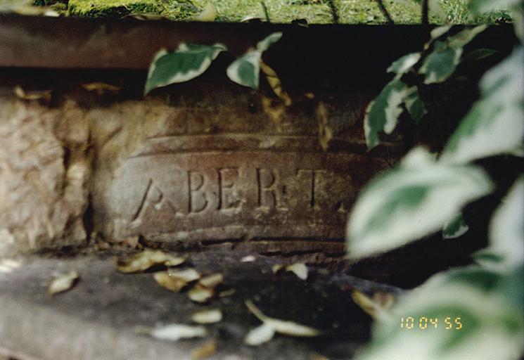 Logis : vue de la pierre de la dépendance détruite remployée sur le soubassement.