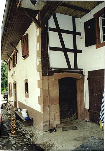 Vue de l'élévation sur cour du logis (No 4) avec porte vers le hangar.