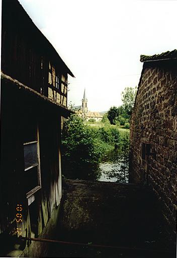 Vue depuis la passerelle sur la Sauer, avec ancienne scierie à gauche et corps de bâtiment accolé au moulin à droite.