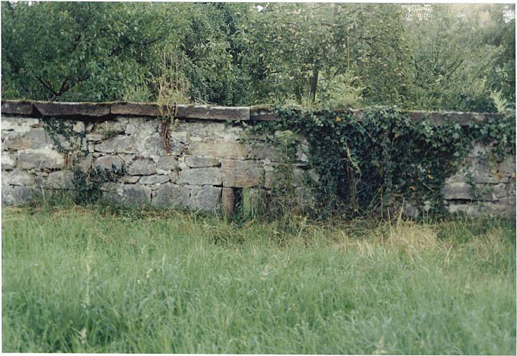 Détail du mur d'enceinte au sud de l'église, avec jour en archère.