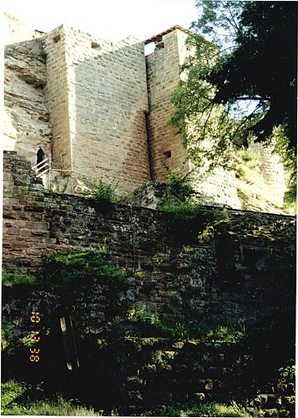 Vue partielle du château côté nord : braie et courtine à la hauteur de la porte de la basse cour et contre le rocher, tour du puits et tour d'escalier du château.