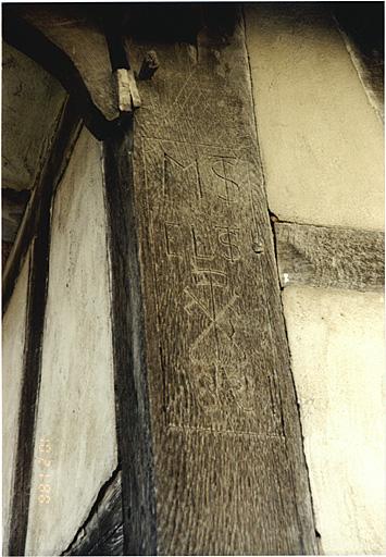 Dépendance à pignon sur rue. Détail du poteau cornier avec emblème de tonnelier et date 1881.