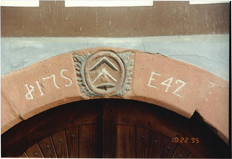 Ancienne ferme de tailleur de pierre, 57, rue de la Halle. Détail de la porte de la cave avec emblème et date 1742.