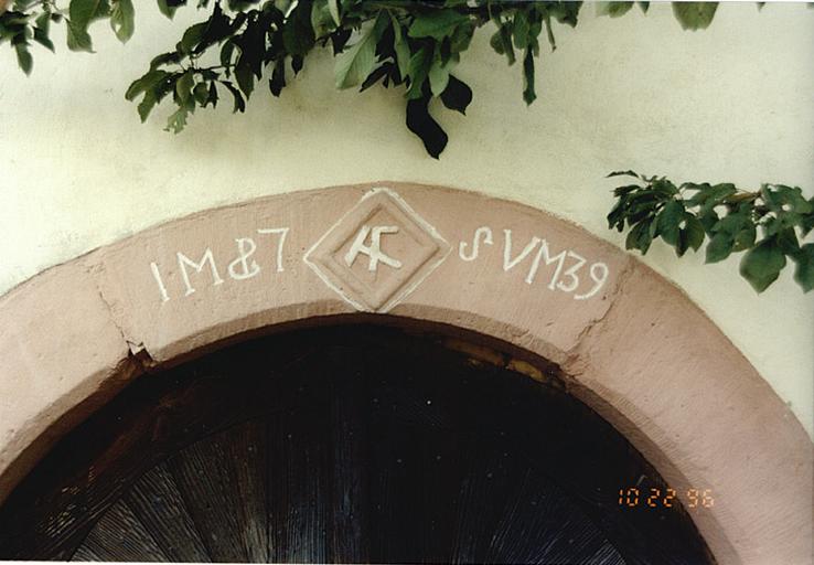 Ancienne ferme de tailleur de pierre, 63, rue de la Halle. Détail de la porte de la cave avec emblème et date 1739.
