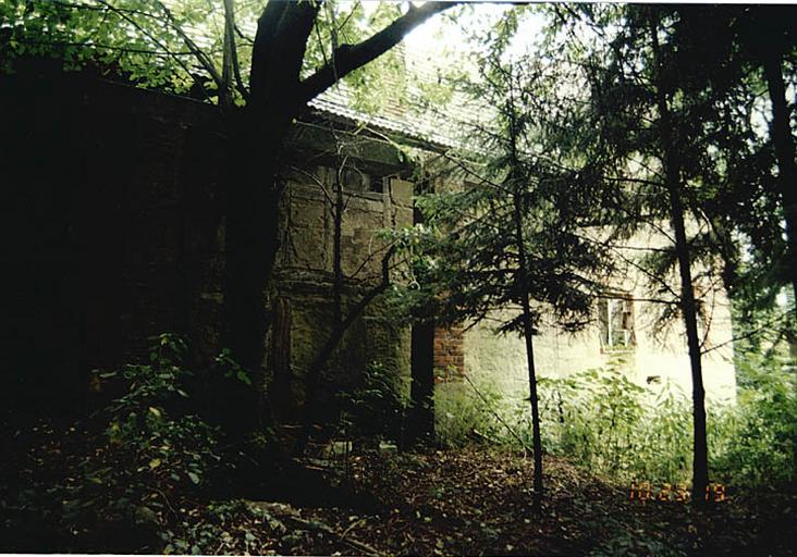 Vue de l'élévation postérieure de la dépendance du moulin avec rigole de l'amenée d'eau (sous le toit) et partie moulin du logis avec trou de fixation de la roue disparue.