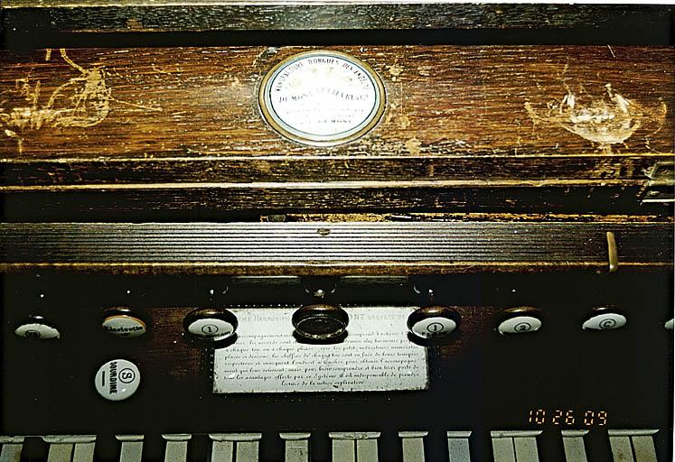 Détail de la plaque indiquant le nom du fabricant sur l'harmonium.