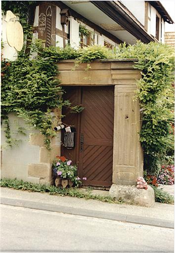 Porte piétonne et clé de voûte au sol.
