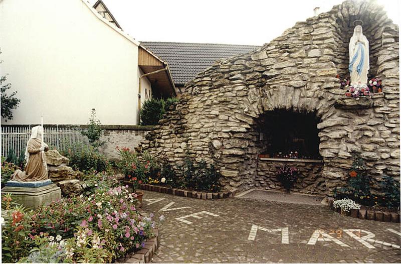 Vue d'ensemble de la grotte de Lourdes et des statues de la Vierge et de Bernadette en fonte.