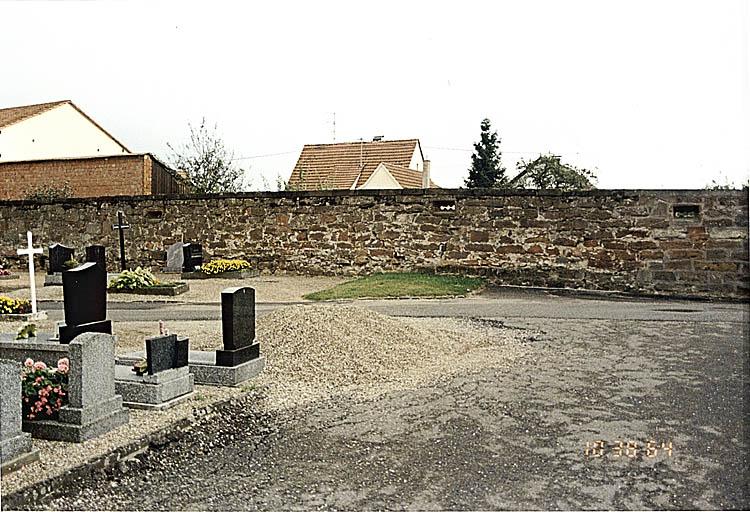 Vue du mur sud de l'ancien cimetière fortifié.