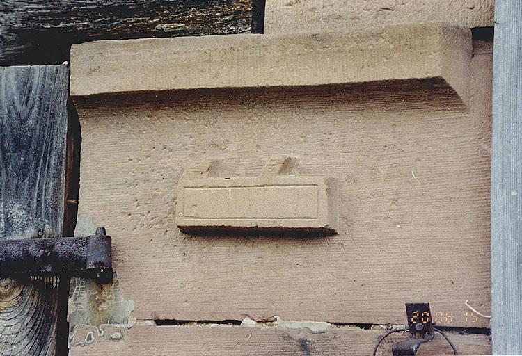 Hinterfeld, vue de la ferme 5, rue Principale, emblème sculpté sur la porte de la grange : rabot.