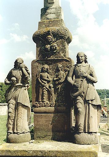 Détail des statues et du relief sur le socle de la croix.