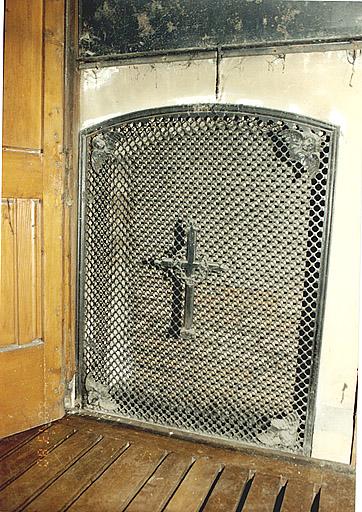 Grille pour le chauffage, placée derrière un panneau du lambris.