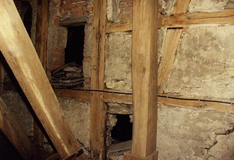 Tour, dernier niveau en pan de bois : mur percé d'une baie en plein cintre.