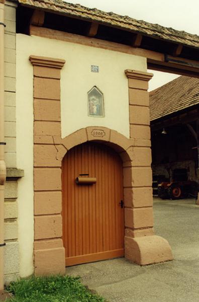 Ferme, 212 rue Principale : porte piétonne datée 1808 surmontée d'une niche avec un groupe de la sainte Famille.
