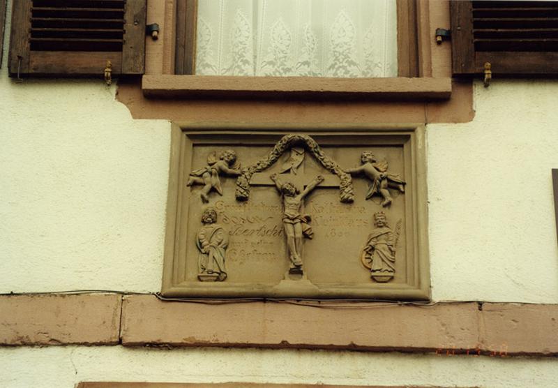 Ferme, 43 rue des Seigneurs : relief sur un mur du logis, daté 1850, représentant le Christ en croix, saint Joseph et sainte Catherine.