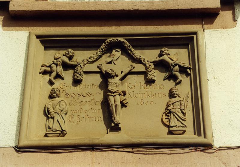 Ferme, 43 rue des Seigneurs : relief daté 1850, représentant le Christ en croix, saint Joseph et sainte Catherine.