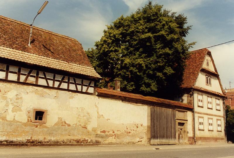 Vue du logis et des portes charretière et piétonne sur rue.