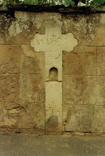Croix de chemin (B), encastrée dans le mur de clôture de la ferme, 77 rue Principale.