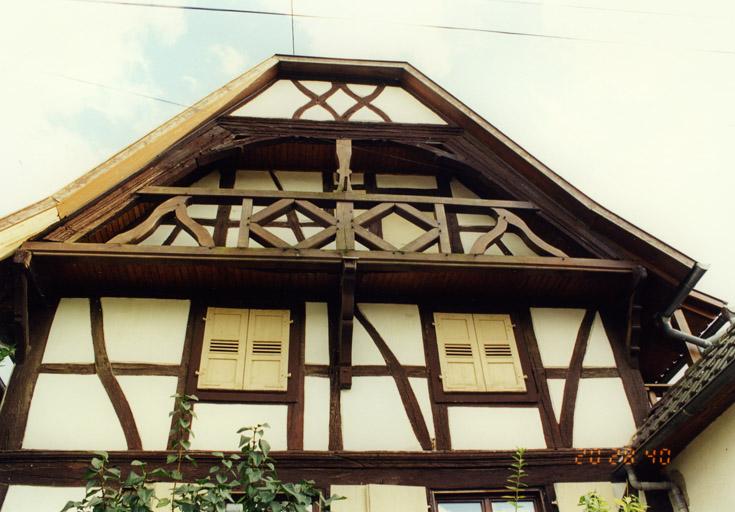 Ferme, 52 Grand'rue : mur-pignon du logis, coursière en encorbellement, au garde-corps remplacé au 20e siècle.