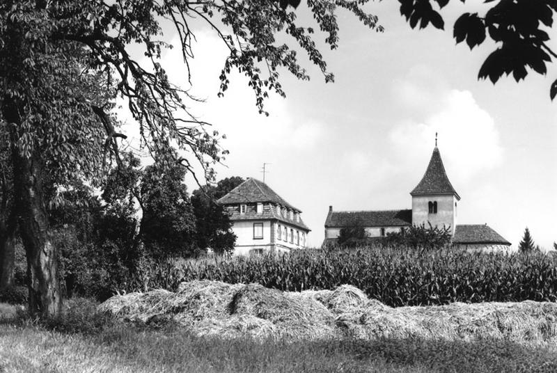 Vue d'ensemble éloignée avec le presbytère depuis la D. 67.