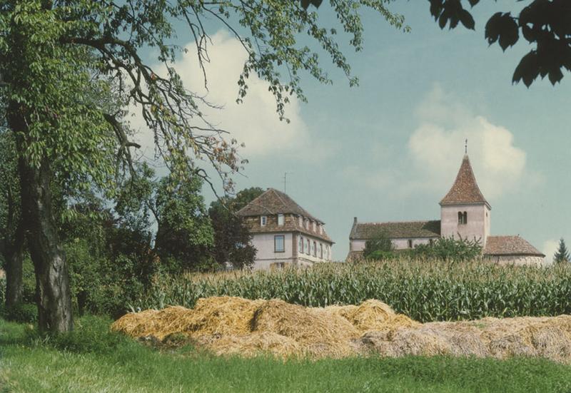 Vue d'ensemble éloignée avec le presbytère depuis la D. 67.