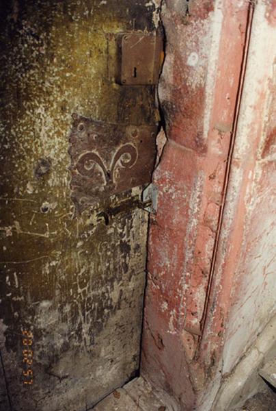 Tour, rez-de-chaussée, chambranle mouluré de la porte dans le mur nord et serrure ancienne.