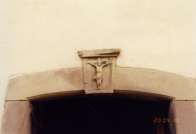 Ferme, 2, rue de la Chapelle : porte de l'étable avec fausse clef sculptée d'un Christ en croix.