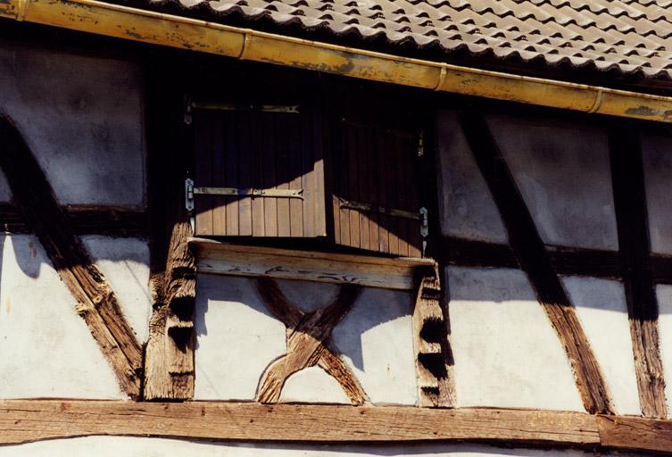 Détail d'une fenêtre à chambranle saillant et chaise curule d'allège, dans un logis entièrement remanié.