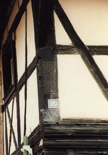 Logis, poteau cornier sculpté au 1er étage, à gauche.