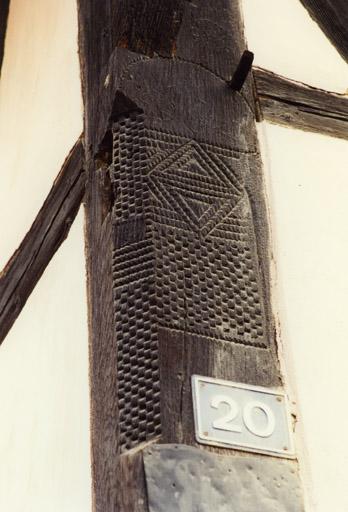 Logis, détail du poteau cornier sculpté à gauche.