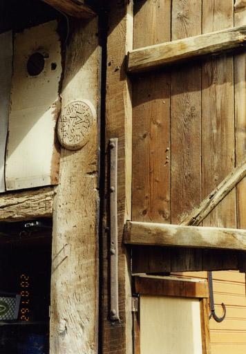 Grange, montant de la porte sculpté d'un médaillon.